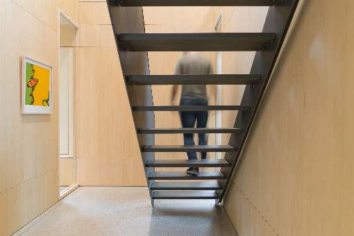 Foto 3: Die dunklen Treppen heben sich kontraststark von den furnierten Wandverkleidungen ab. Foto: IFN/Europlac